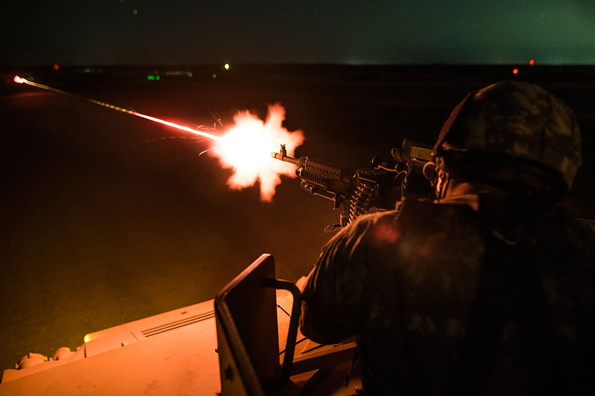 soldier firing weapon at night during training.